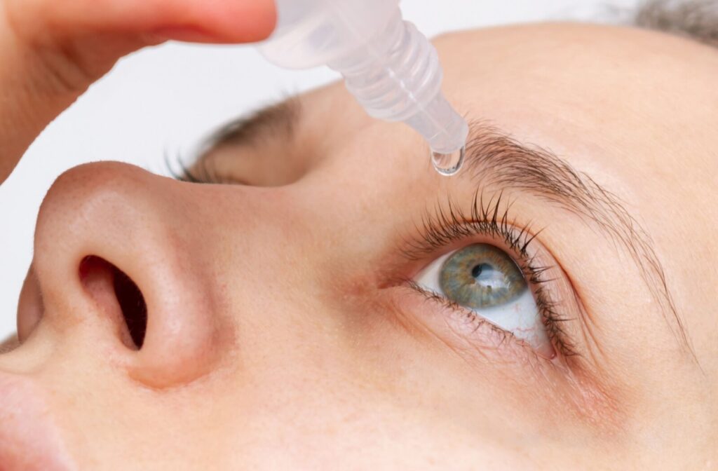 Upclose shot of someone putting eyedrops in their eyes.