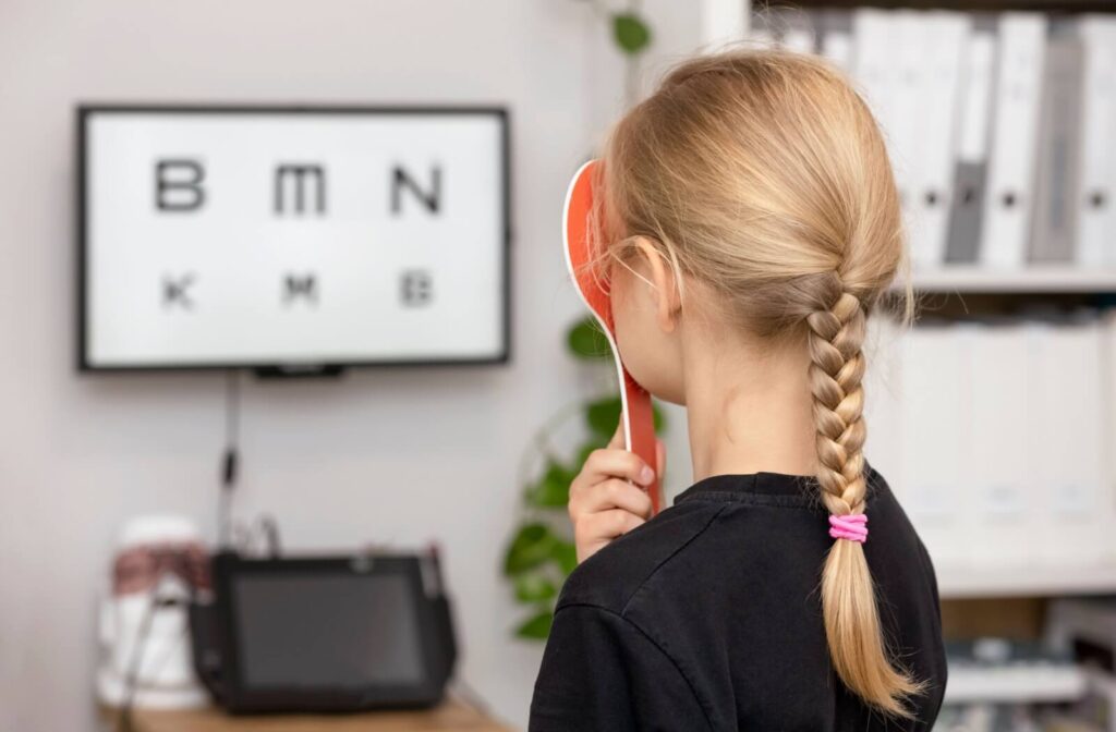 A child undergoing a vision test using an eye chart.
